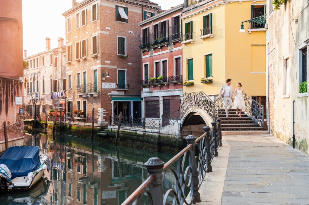 Italy, Venice, bridal couple walking on little bridge