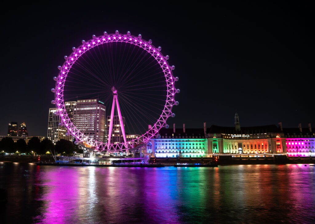 Night view of a colorful London eye with the Cruise river reflecting it