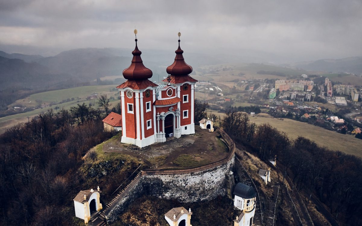 Aerial view of historical church atop on hill. Late baroque calvary in Banska Stiavnica in Slovakia | SUPERPOBYT Travel